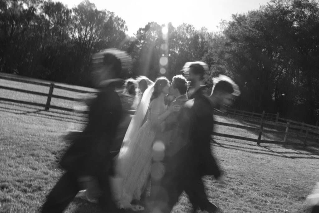 Blurry image of newlyweds kissing.