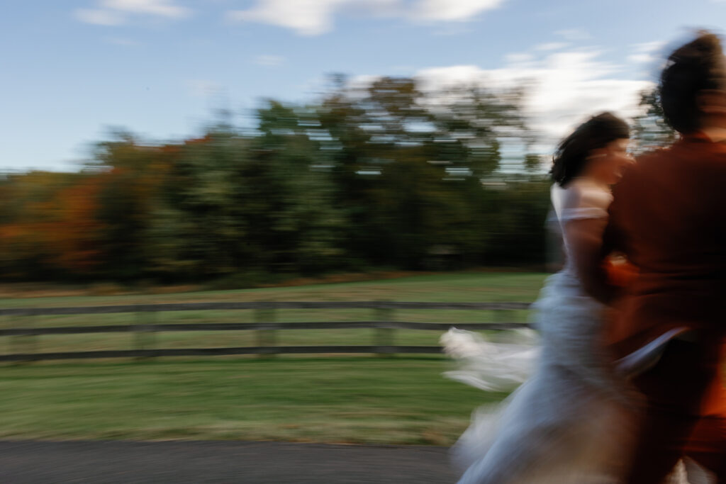 Newlyweds running through a field.