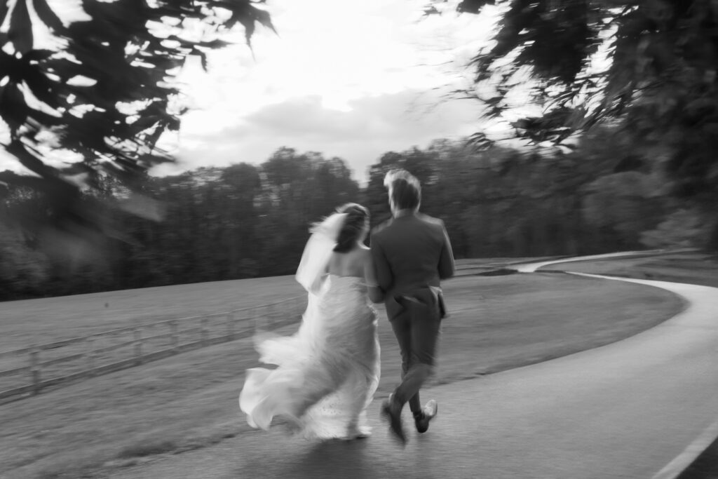 Blurry image of newlyweds running down a road.