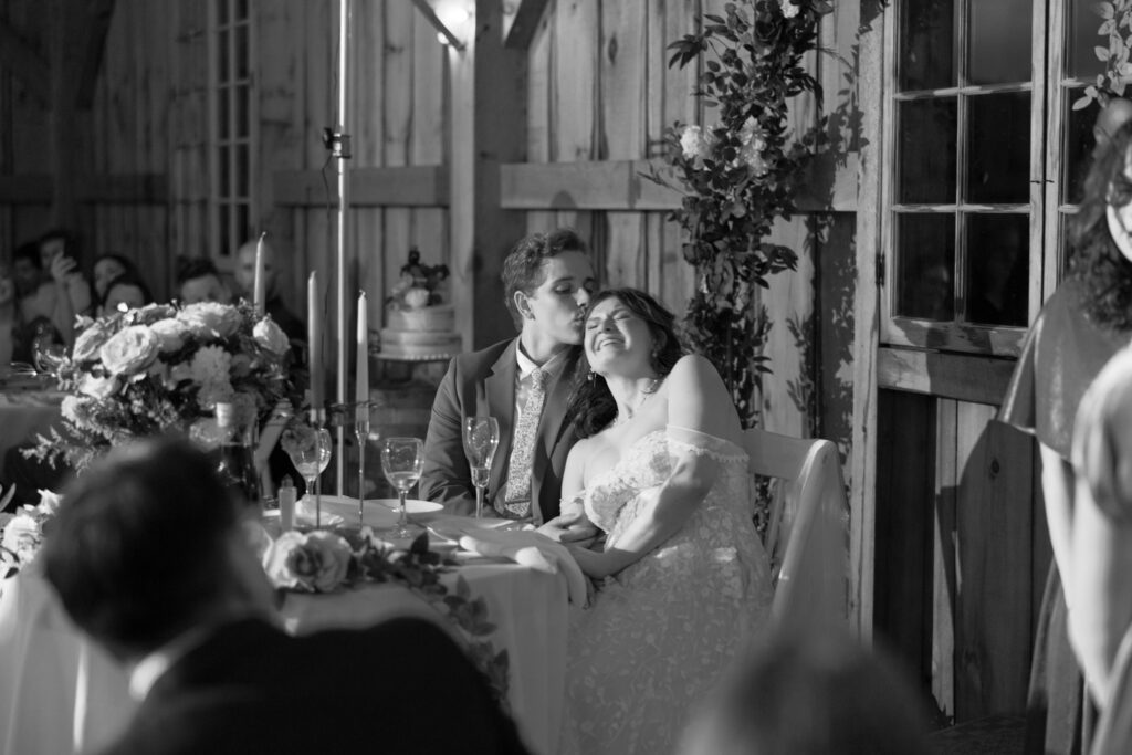 Black and white of a bride crying during speeches.